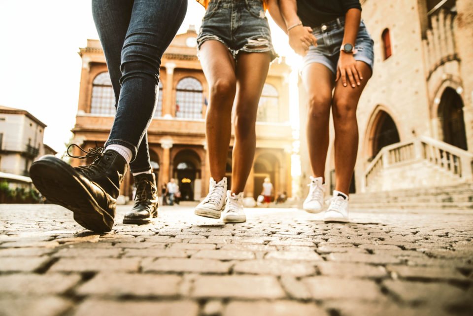 Women friends walking outdoors at sunset