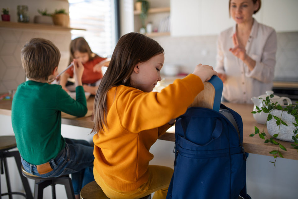 Family in kitchen getting ready for school