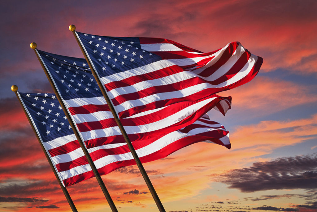 Three US Flags Waving with Red Sky Background