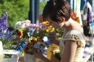 Woman looking at flowers at the Peddler Show Summer Market