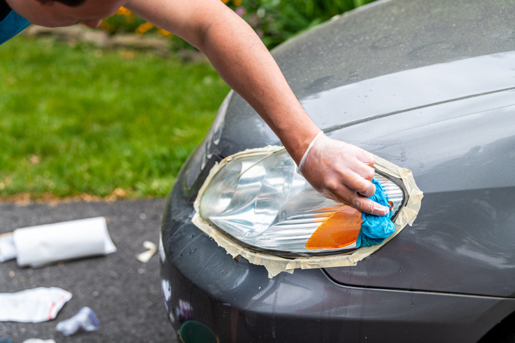 A person cleaning headlights
